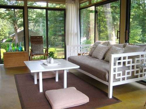 sunroomaftersmall glass doored sunroom with golden yellow stained concrete floors and white daybed and coffee table